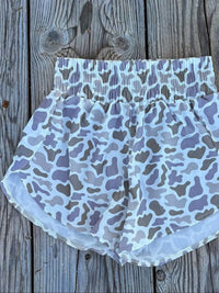 Camouflage-patterned shorts on a wooden surface