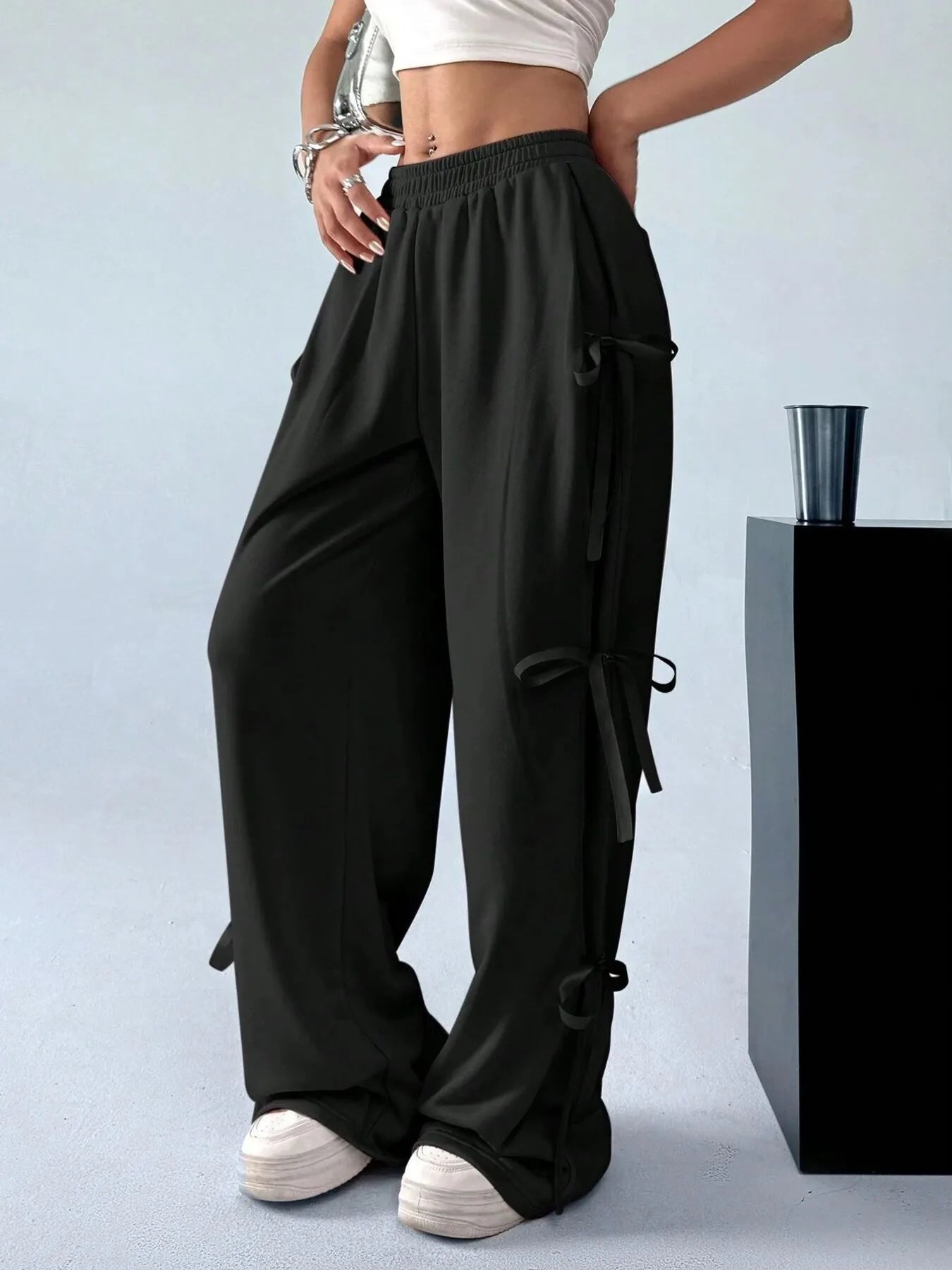 Black wide-leg pants worn by a person on a light gray background