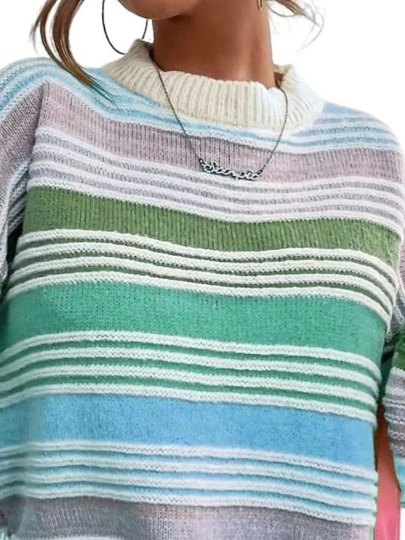 Close-up of a person wearing a colorful striped sweater with a necklace.
