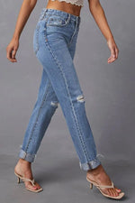 Person wearing blue jeans on a gray background