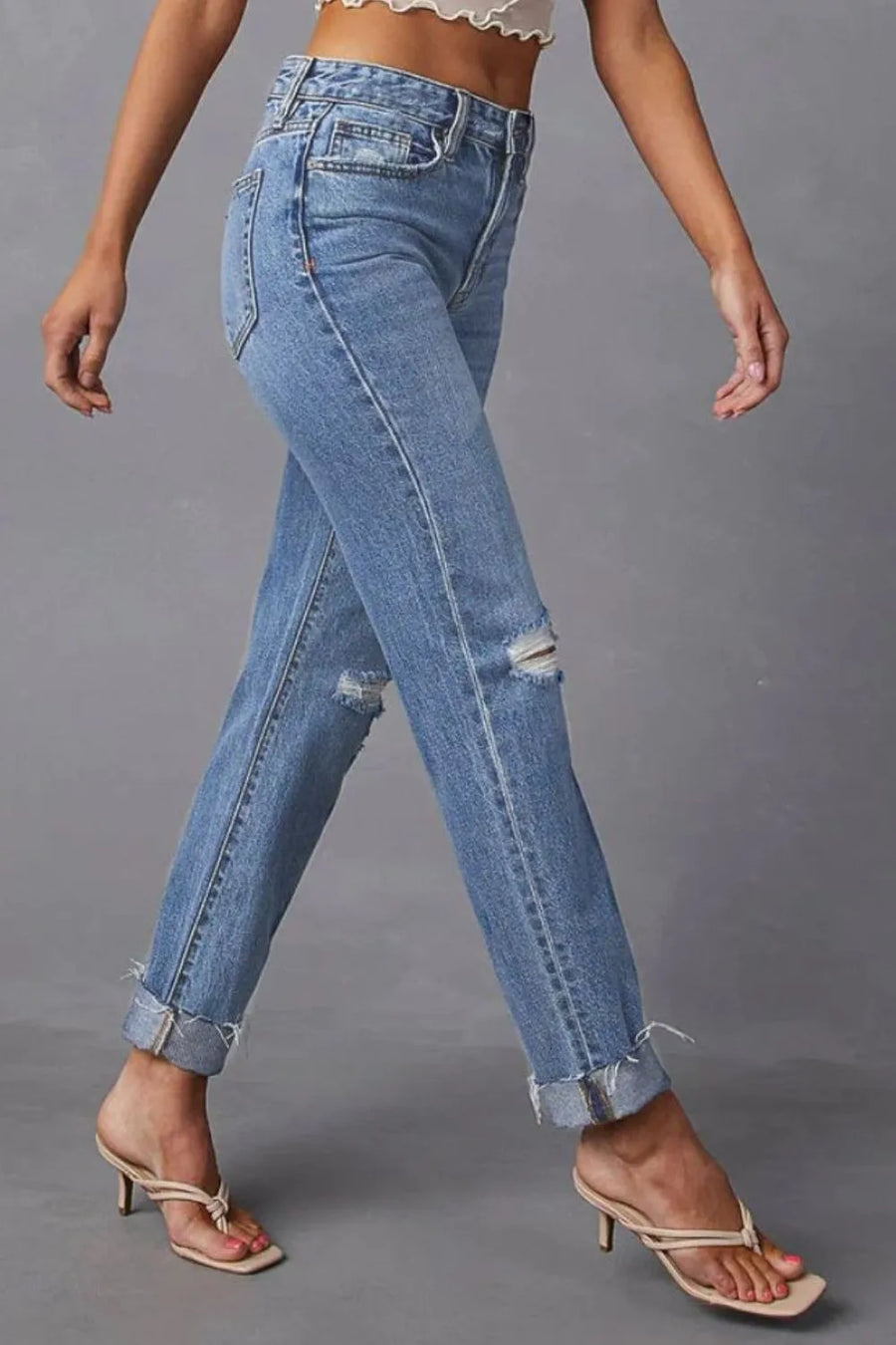 Person wearing blue jeans on a gray background