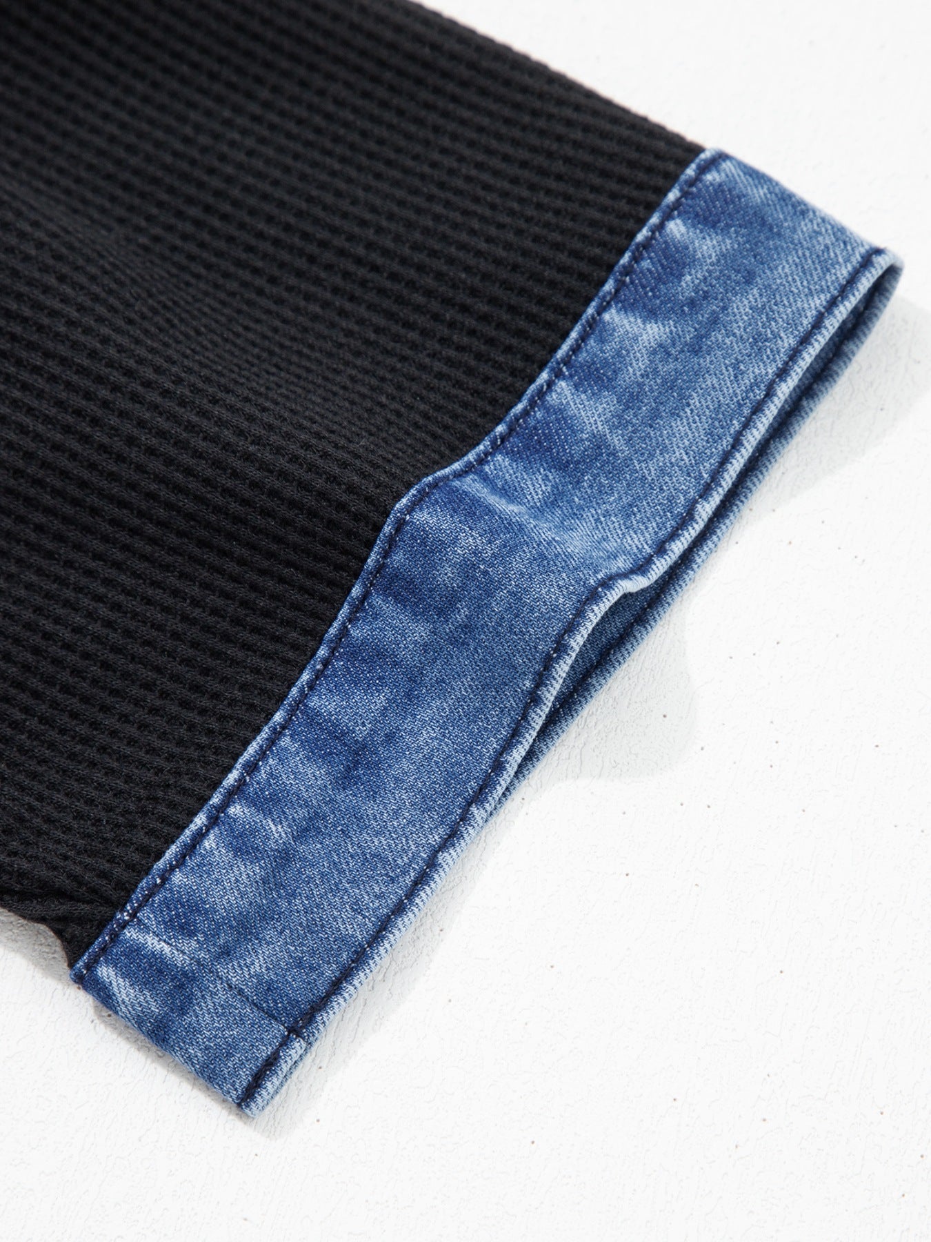 Black fabric with blue denim edge on a white background