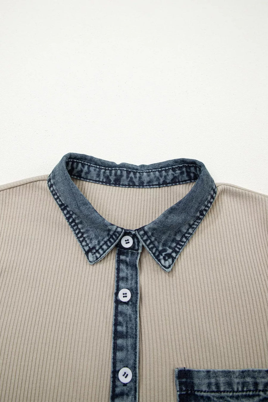 Beige shirt with denim collar and buttons on a light gray background