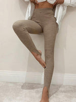 Person wearing brown leggings against a plain background