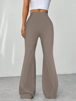 Brown flared pants worn by a person on a plain background