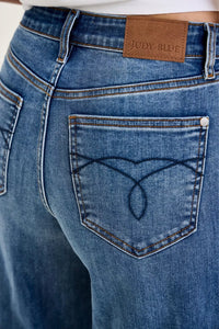 Close-up of blue jeans with a brand label on the back pocket.