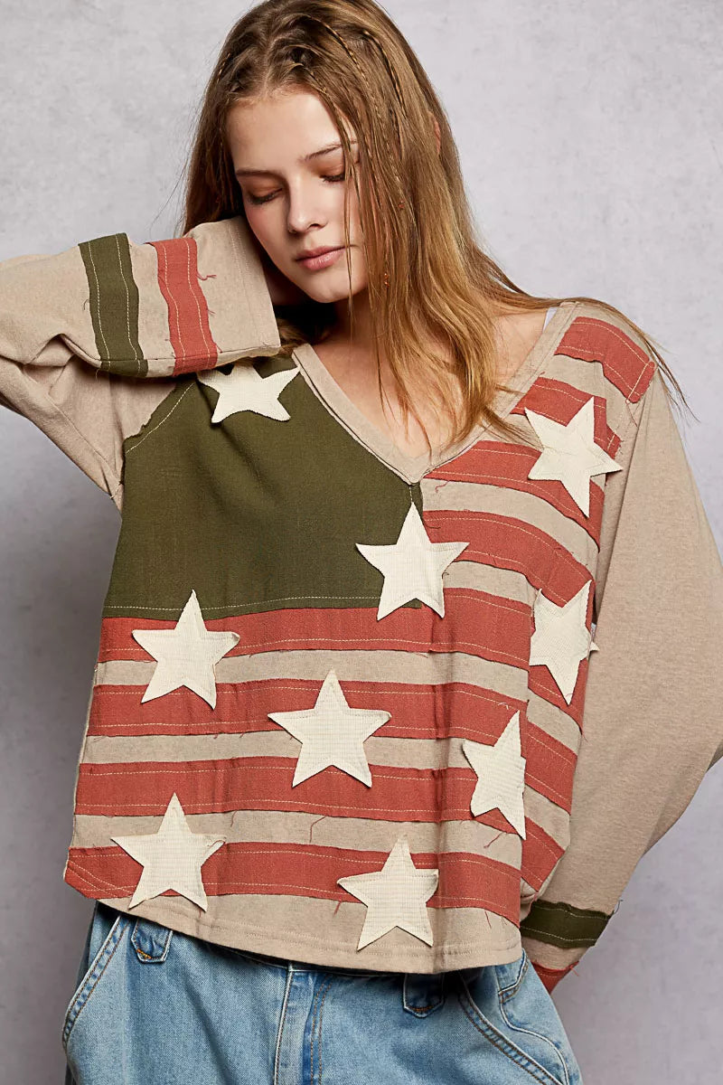 Woman wearing a sweater with American flag design on a plain background