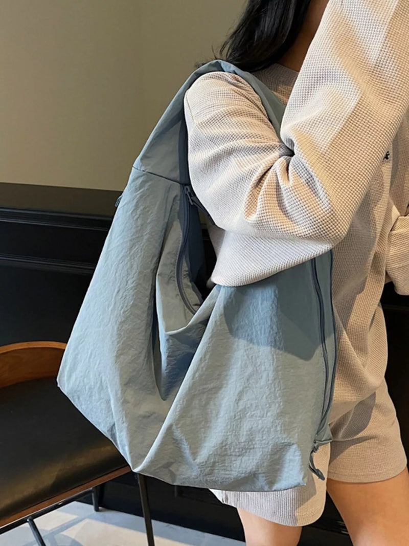 Person holding a light blue tote bag indoors