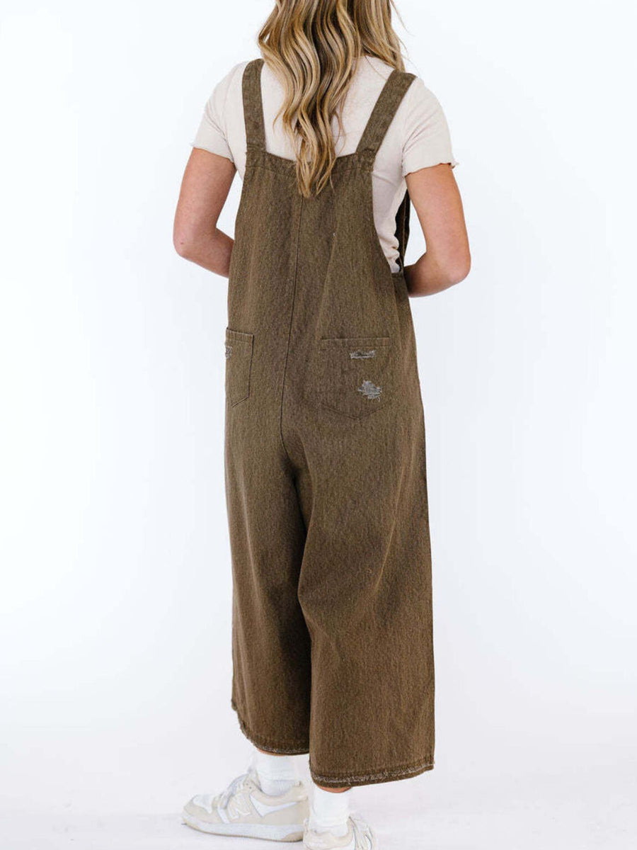 Person wearing brown overalls on a white background