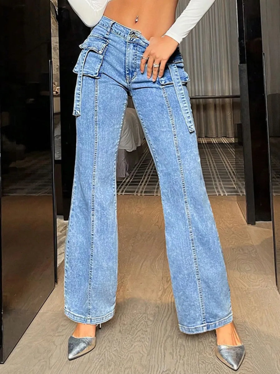 Person wearing high-waisted blue jeans with a blurred indoor background