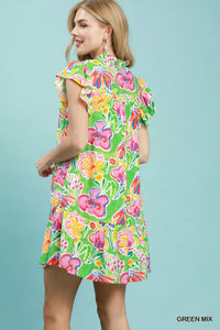 Woman wearing a colorful floral dress against a light blue background