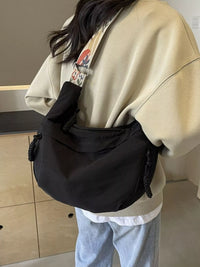 Person wearing a black waist bag with a colorful strap in an indoor setting