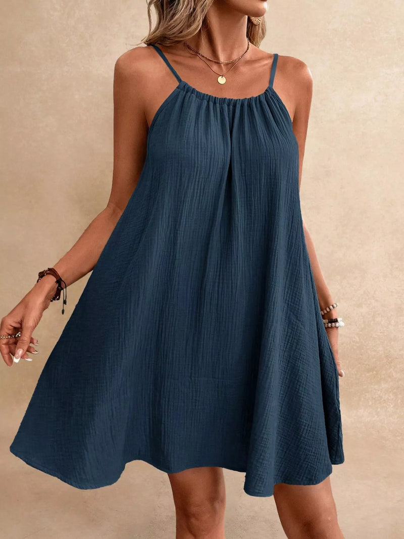 Woman wearing a blue dress against a beige background