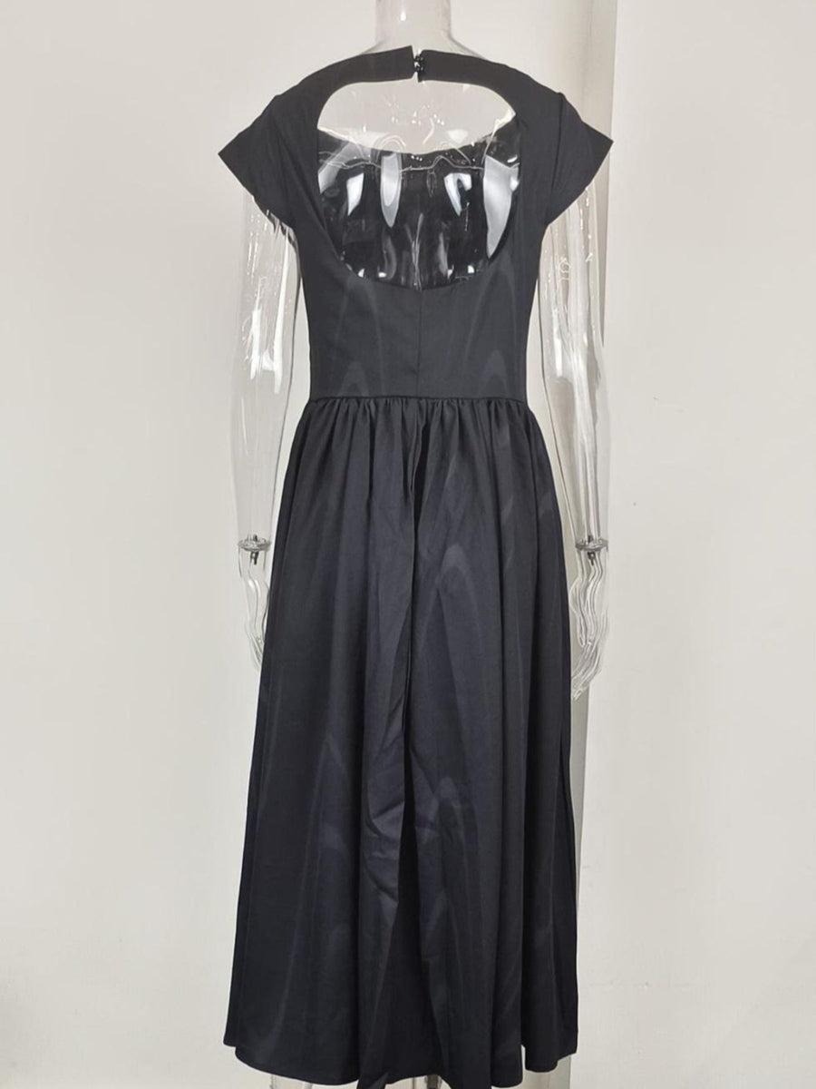 Black dress with sheer panels on a white background