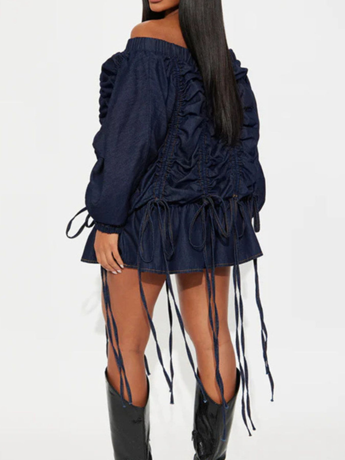 Navy off-shoulder dress with ruched details and long boots on a white background