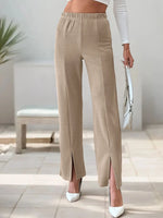 Beige wide-leg pants worn by a person in a minimal indoor setting.