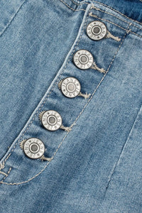 Close-up of blue denim fabric with metal buttons