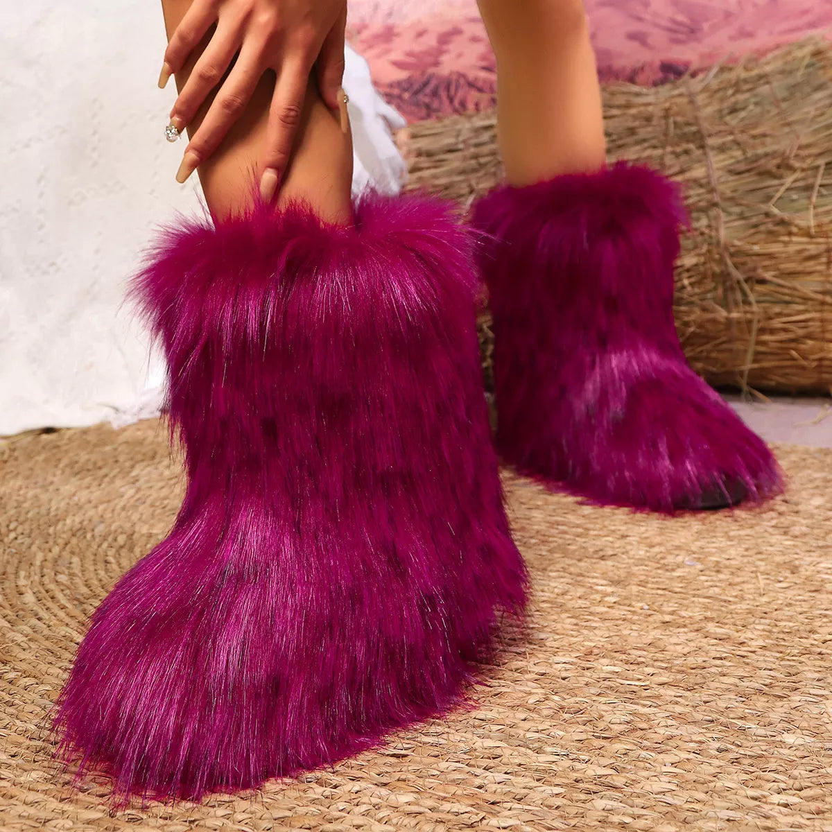 Purple fuzzy boots worn by a person on a textured surface.