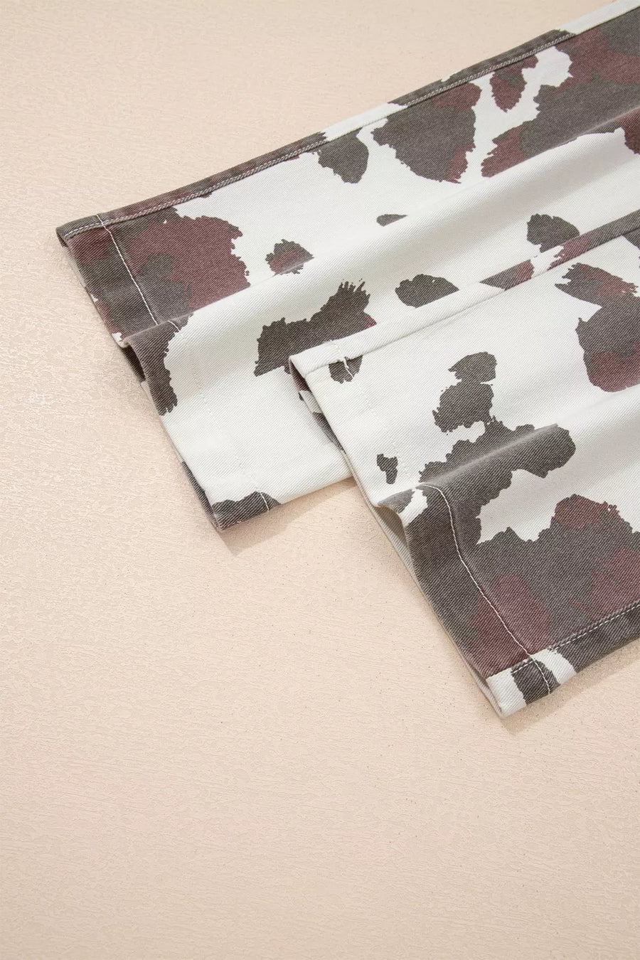 Two cow print napkins on a beige background