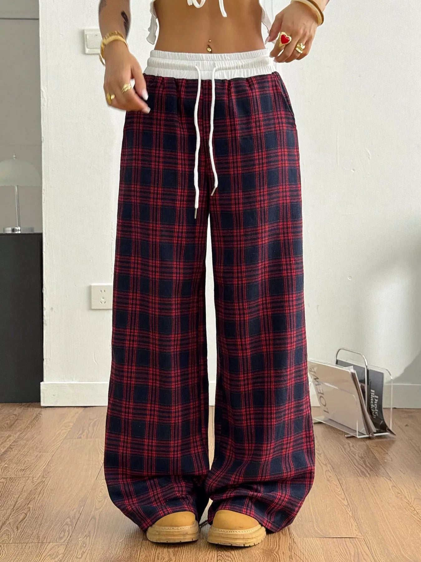 Person wearing red and blue plaid pajama pants indoors.