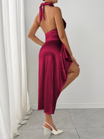 Woman wearing a burgundy dress with a white curtain and floor in the background