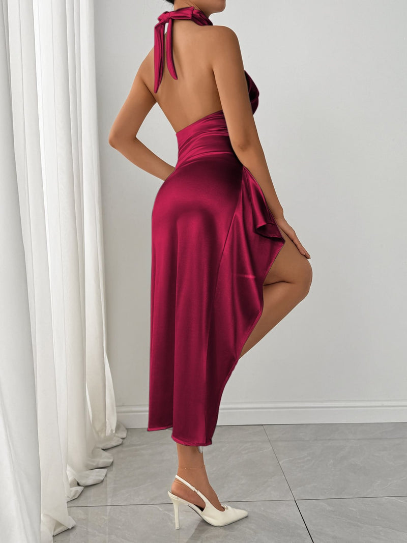 Woman wearing a burgundy dress with a white curtain and floor in the background