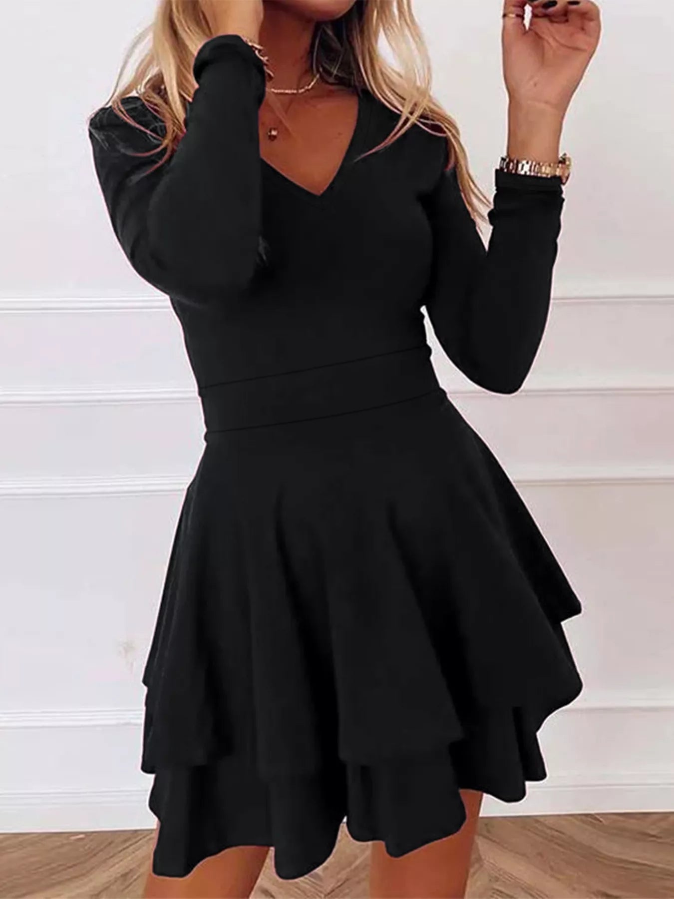 Black dress with long sleeves and a flared skirt on a white background