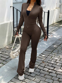 Person wearing a brown outfit walking on a sidewalk.