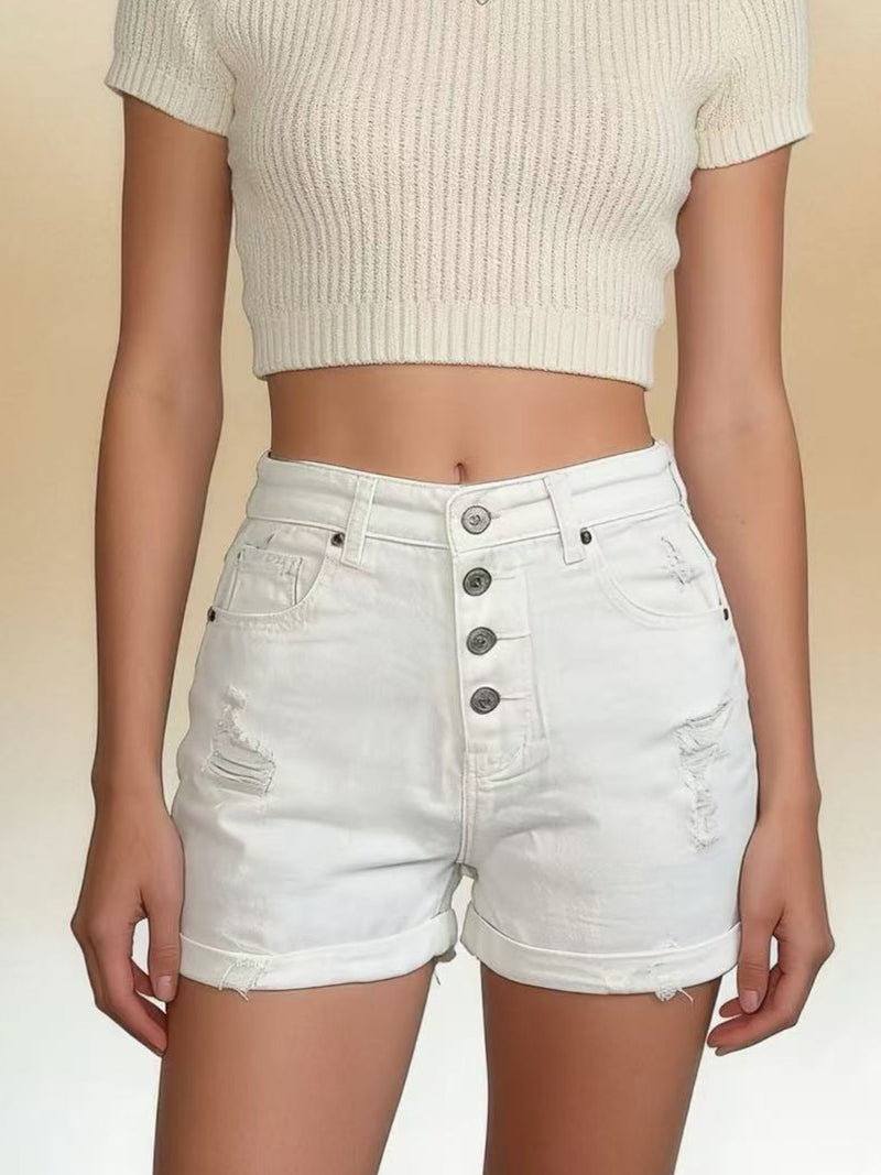 Person wearing a beige ribbed crop top and light denim shorts on a beige background
