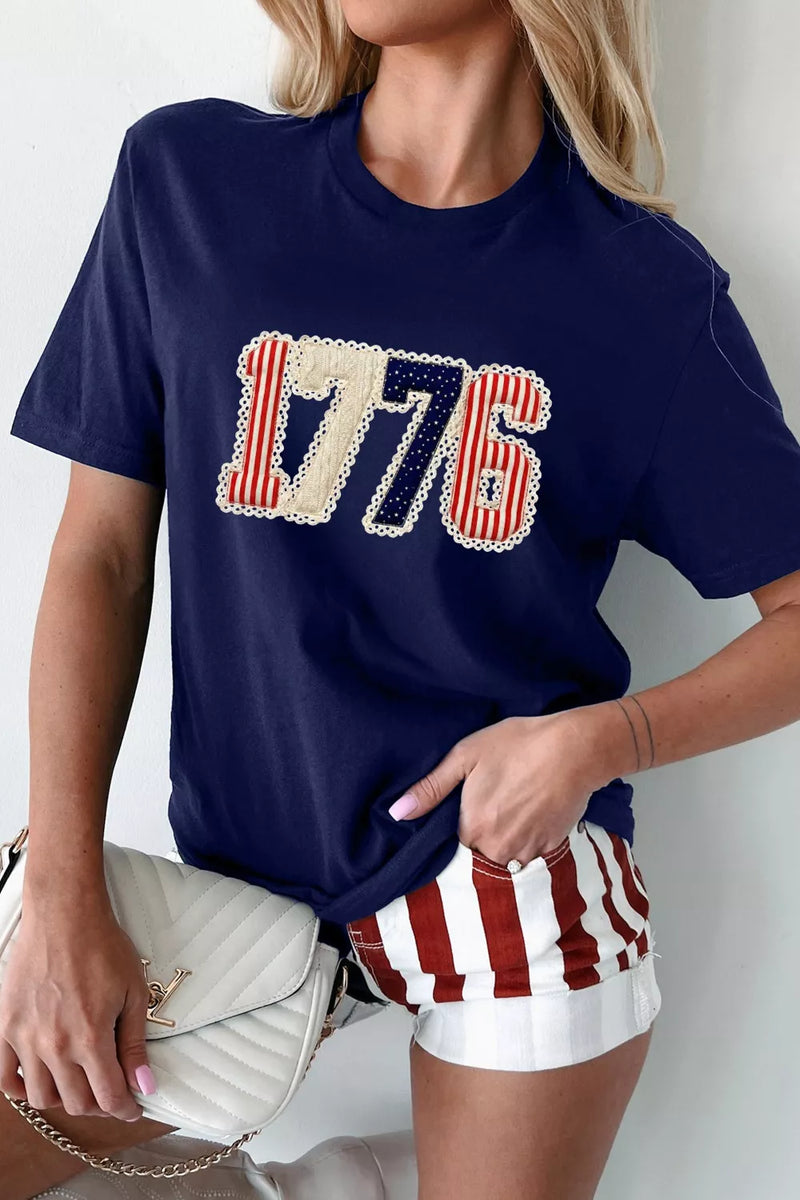 Person wearing a navy blue t-shirt with '1776' design and American flag shorts.