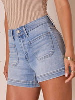 Person wearing light blue denim shorts on a beige background