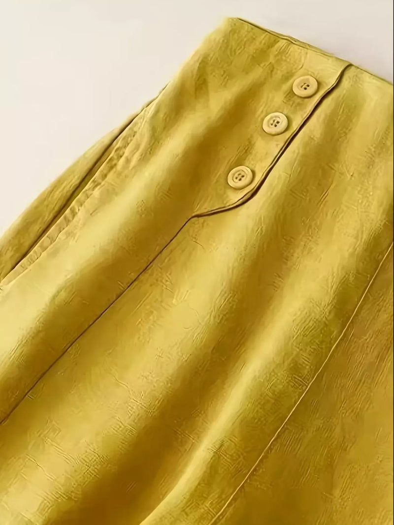 Close-up of a yellow textured fabric with buttons on a light background