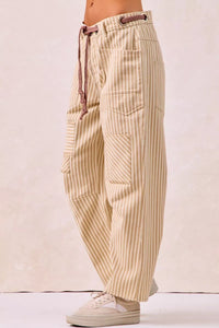 Beige striped pants with a drawstring on a light pink background