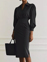 Black dress with puffed sleeves worn by a person against a plain background