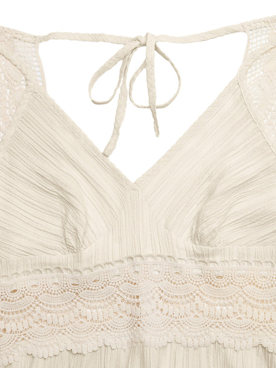 Close-up of a beige lace top with a tie detail on a white background