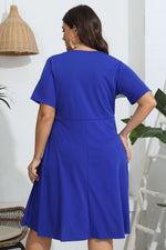 Woman wearing a blue dress in a minimal indoor setting