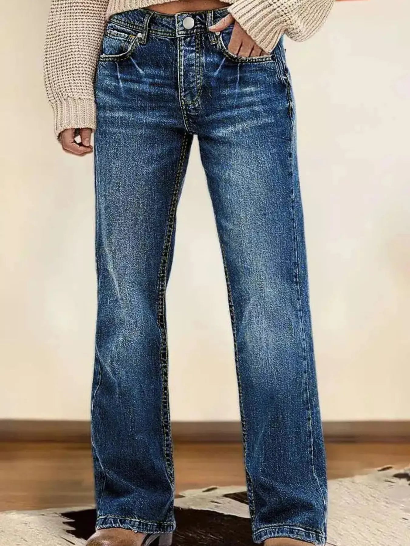 Blue jeans worn by a person on a neutral background