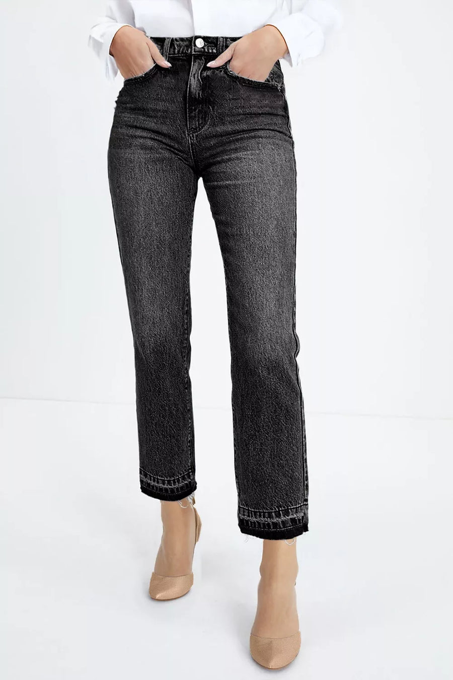 Person wearing black straight-leg jeans on a white background