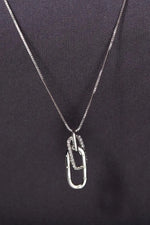 Silver necklace with a unique pendant on a black background