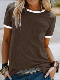 Woman wearing a brown t-shirt with white trim in an outdoor setting