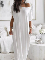 Woman wearing a white off-shoulder dress in a minimalistic room.