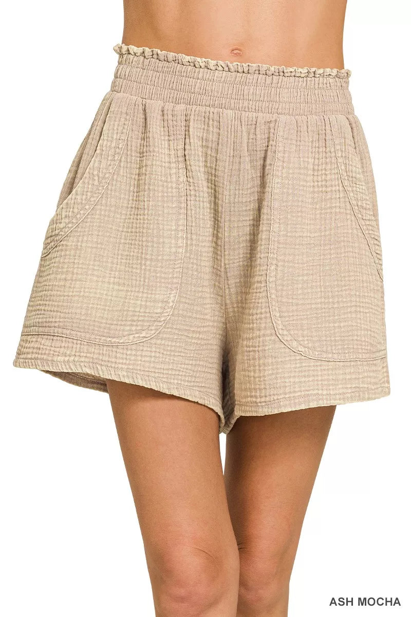 Beige shorts worn by a person on a white background