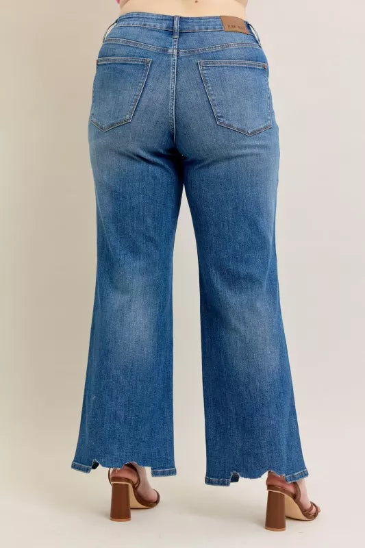 Blue jeans worn by a person on a beige background