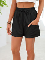 Black shorts worn by a person on a white background