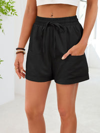 Black shorts worn by a person on a white background