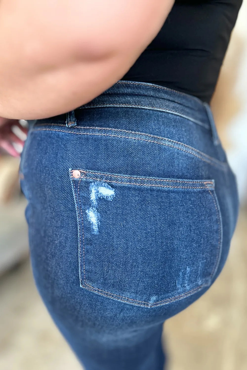 Close-up of blue jeans with a pocket detail on a blurred background
