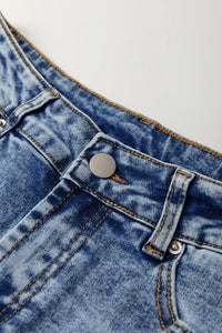 Close-up of blue denim fabric with a button on a white background
