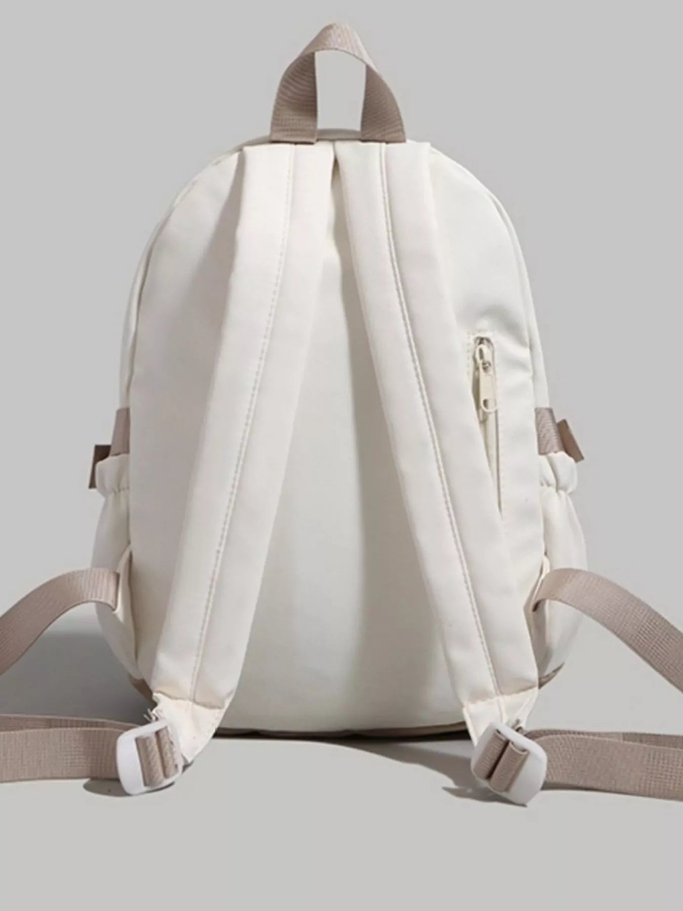 White backpack with beige straps on a light gray background