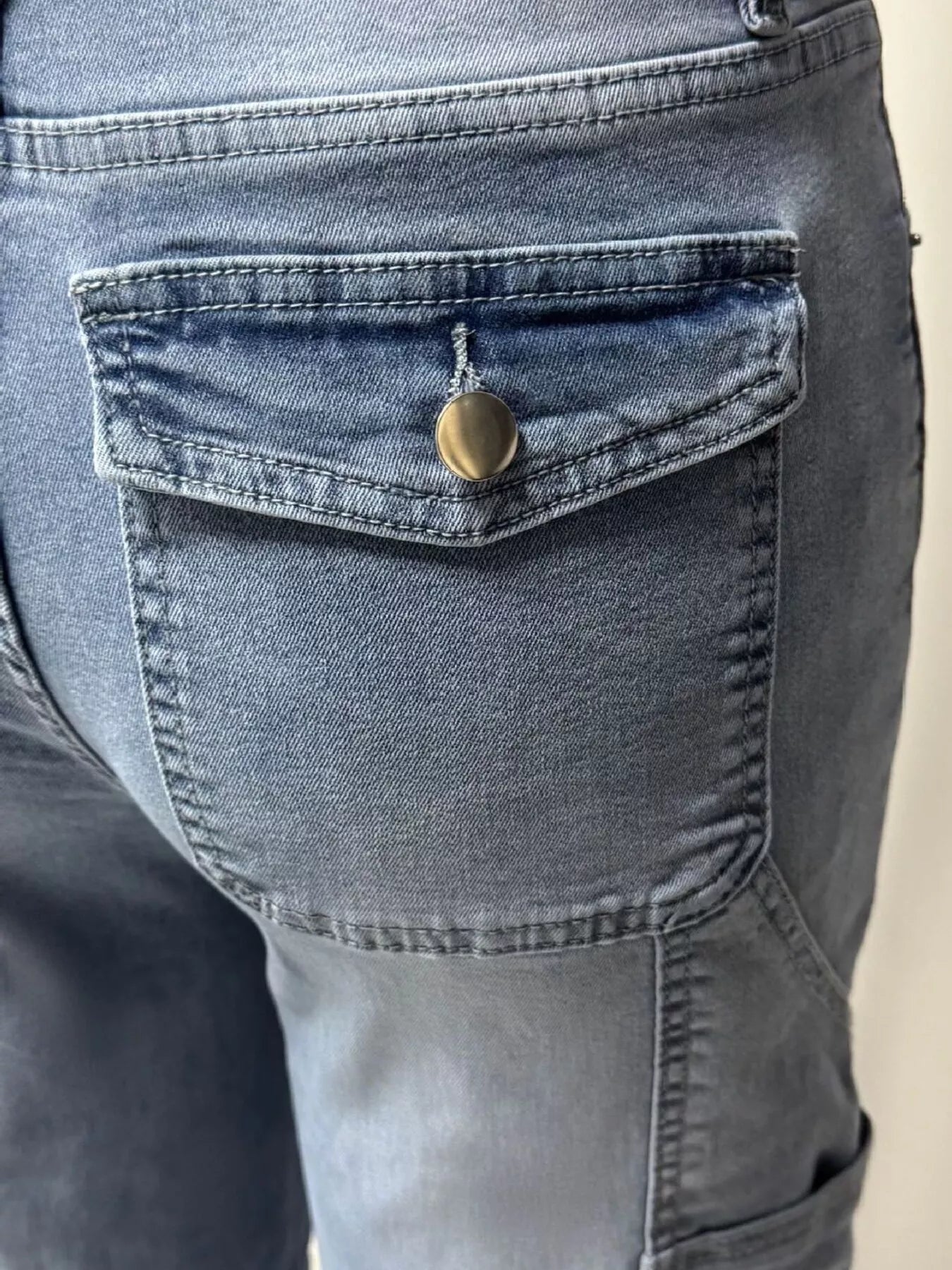 Close-up of a pocket on a pair of blue jeans with a button.