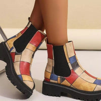 Colorful patterned boots worn by a person on a neutral background